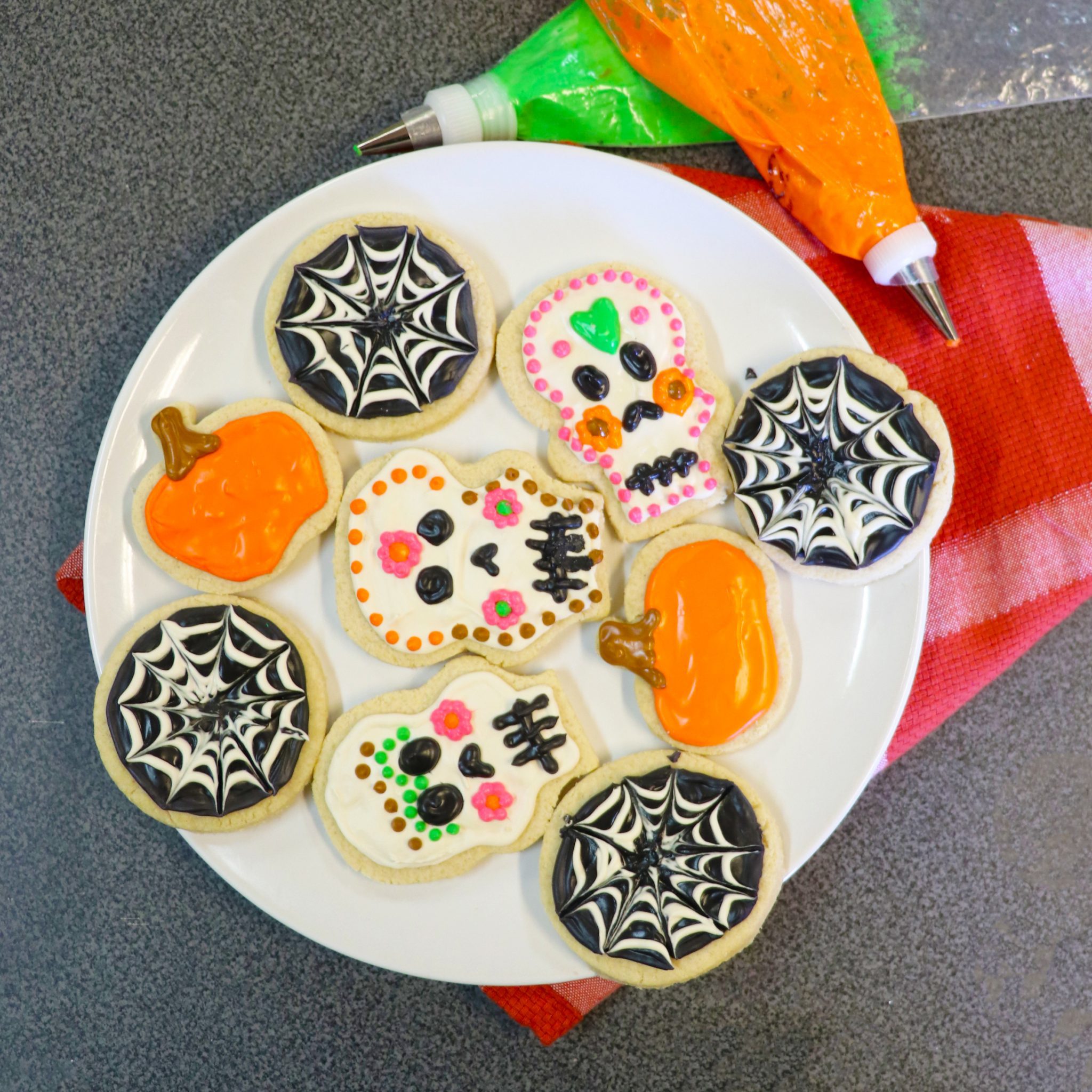 picture of sugar skull, pumpkin, and spider web cookies made for Día de los Muertos